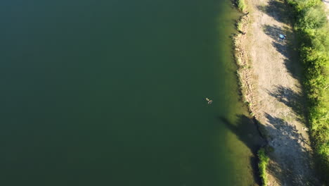 aerial view of a lake with a person swimming