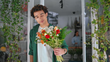 handsome african man enjoy flowers in plant shop. dreamy model look camera.