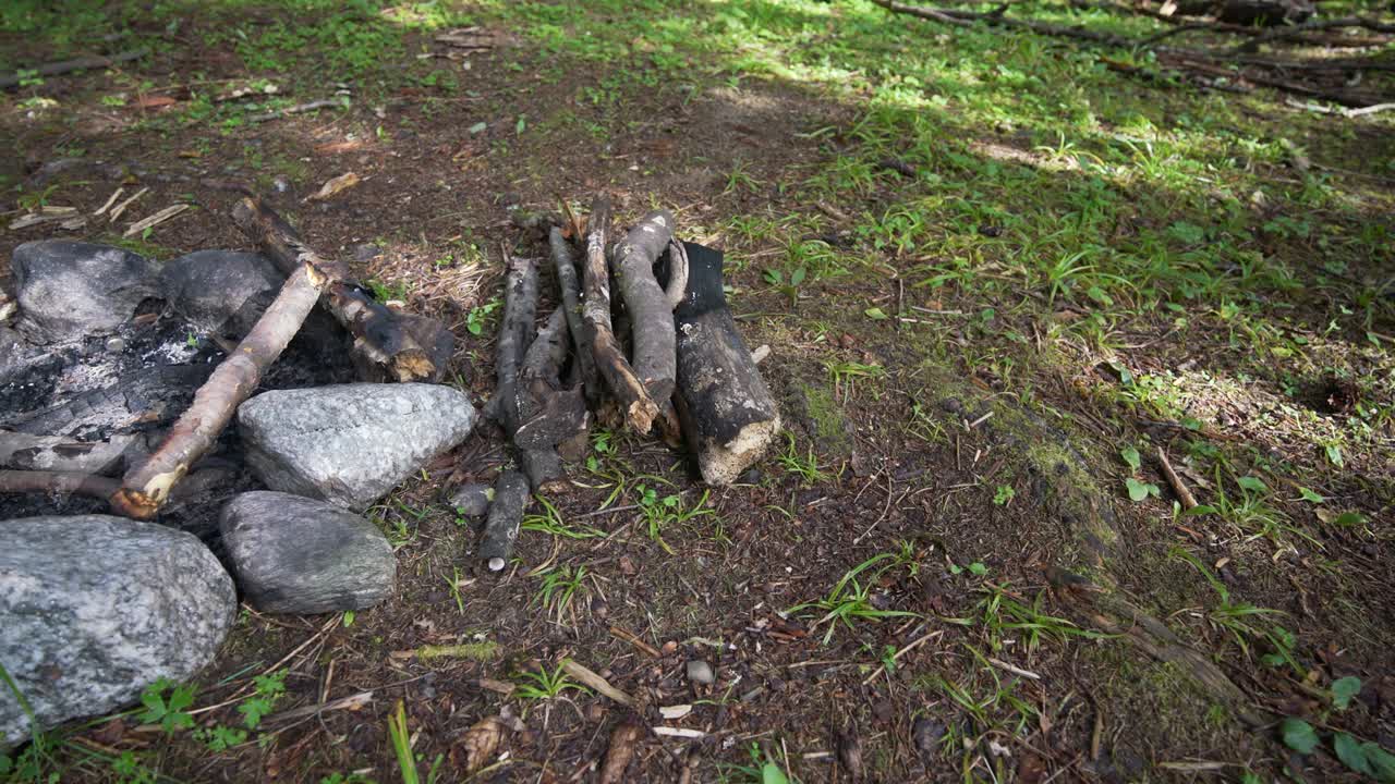 자연에서 꺼진 캠프 불, 벽난로, 불타는 나무를 가진 바위 원