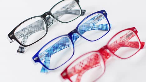 vídeo de tres pares de gafas de colores sobre un fondo blanco con enfoque en rack
