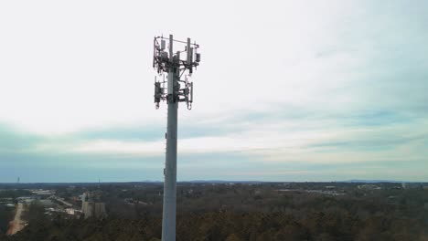 aerial shot rotating around cell phone tower surrounded by forest. 4k drone