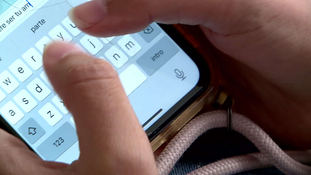 Hands Typing on a Cracked Smartphone