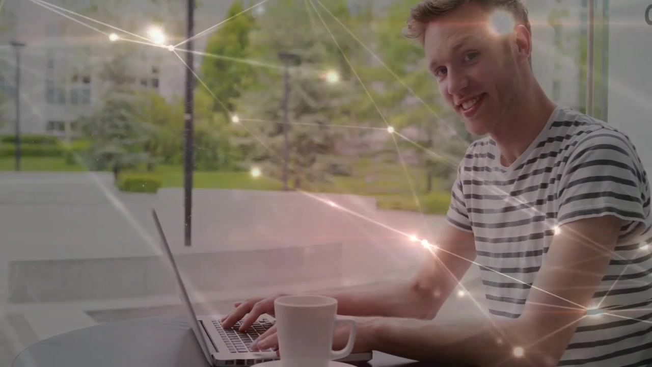 Young Man Working on Laptop with Digital Network Overlay