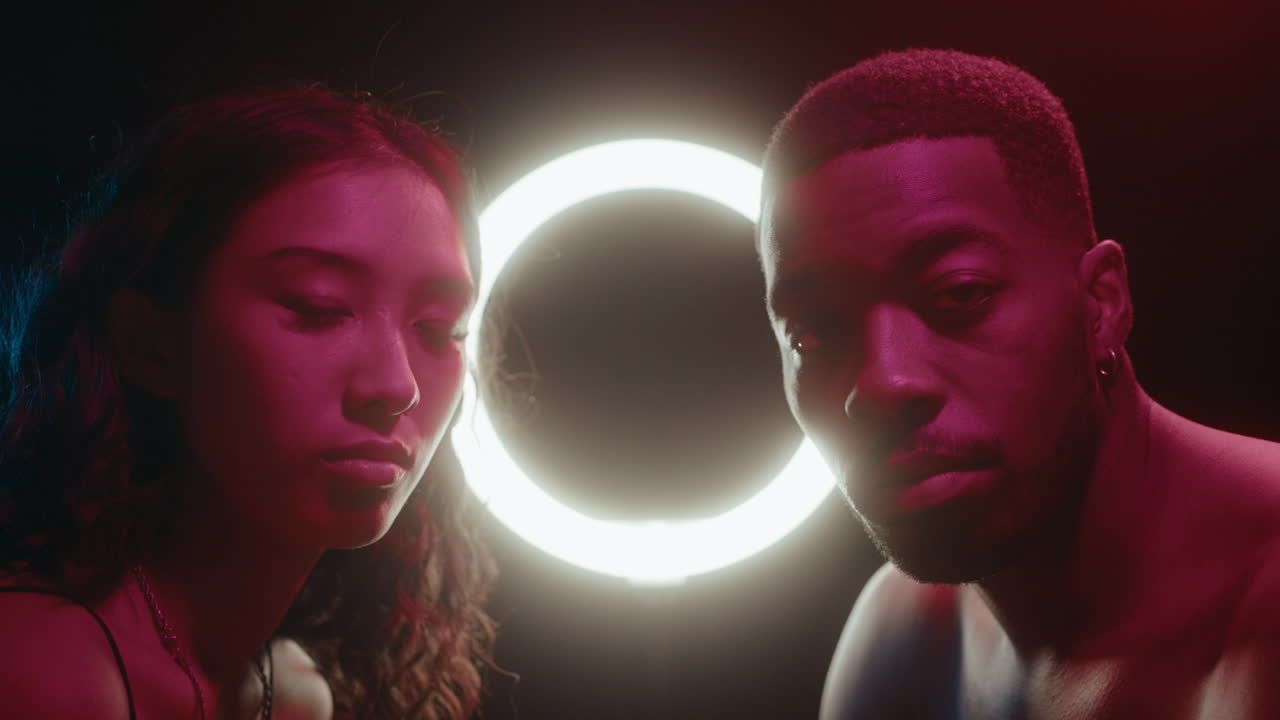 Creative Neon Portrait of Young Man and Woman against Circle Lamp