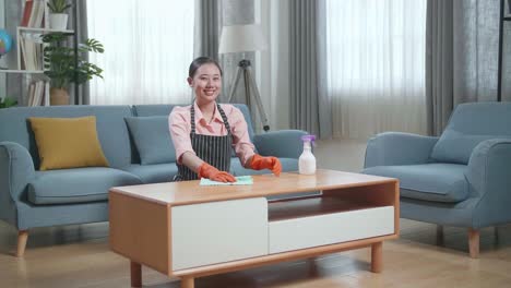 거실 에서 커피 테이블 을 청소 하는 여자