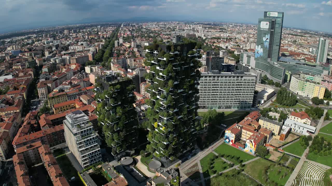 Panoramic drone shots capture a vibrant cityscape, showcasing the Bosco Verticale building draped in lush greenery, with streets winding between the plant-covered facades and urban architecture.