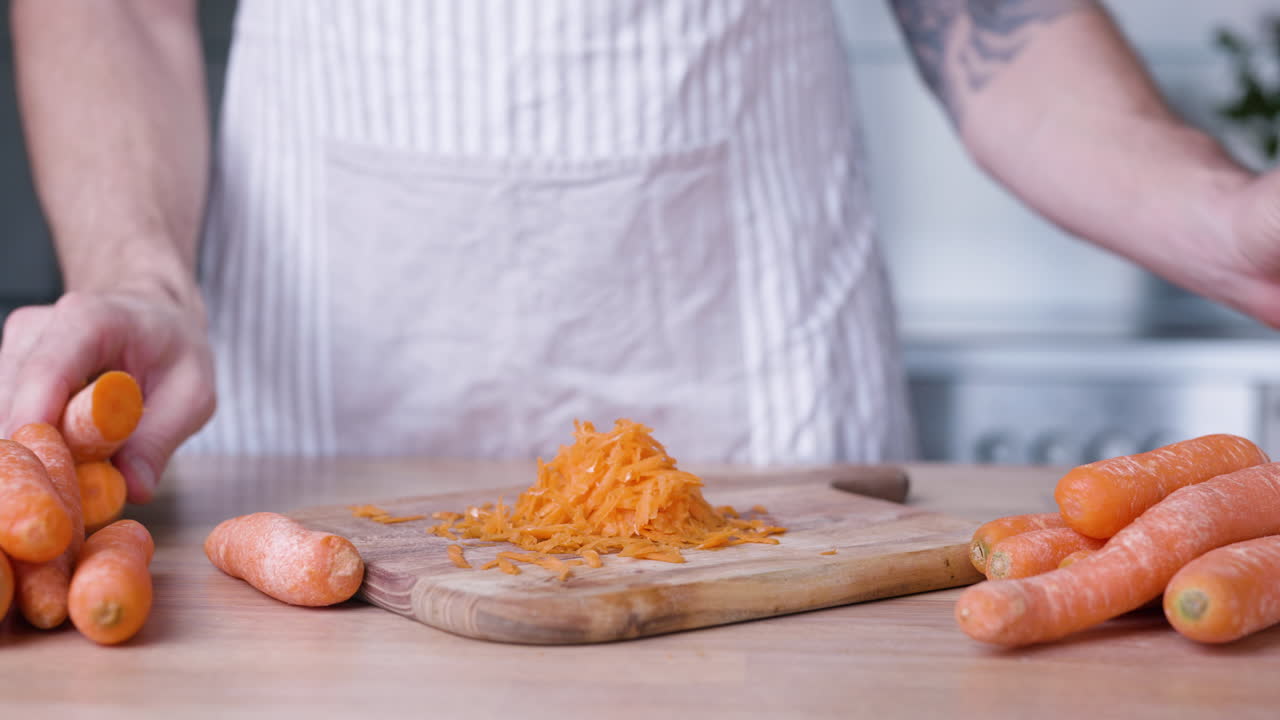 Man Grating Fresh Carrots On Grater For Baking A Delicious Carrot Cake