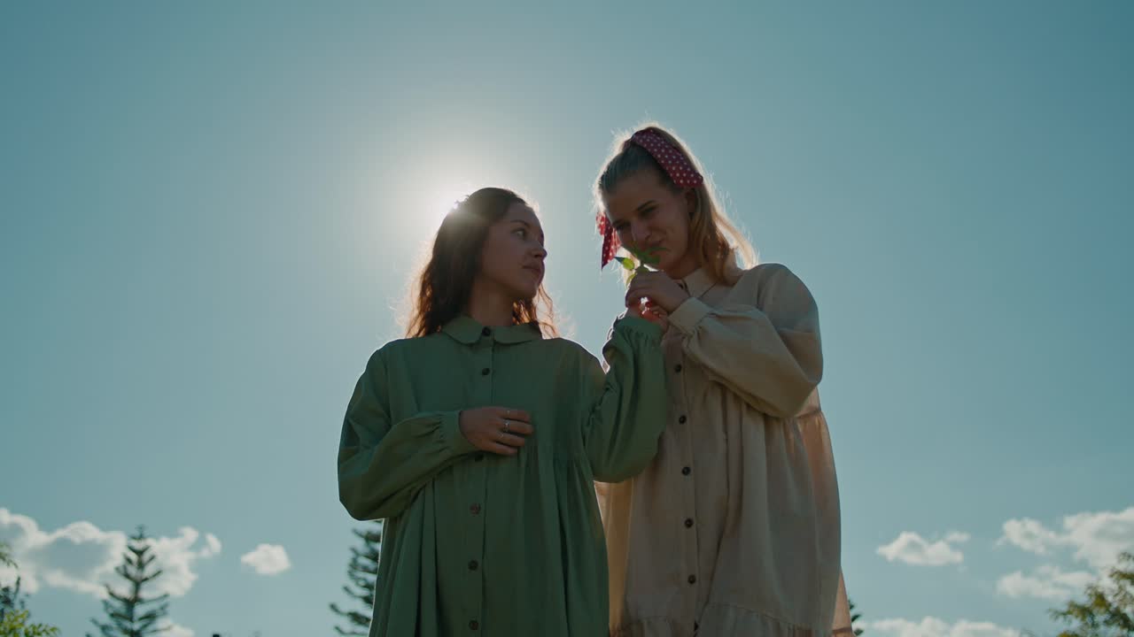 Two women holding a plant outdoors