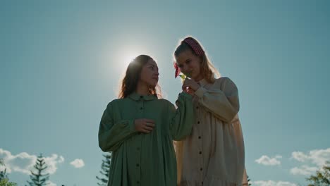 two women holding a plant outdoors