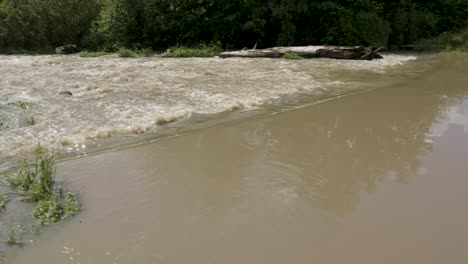 Fast aerial pan of a muddy Keravanjoki River in Kerava, Finland