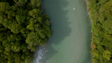 overhead aerial view of clear green river in blue pools in new zealand