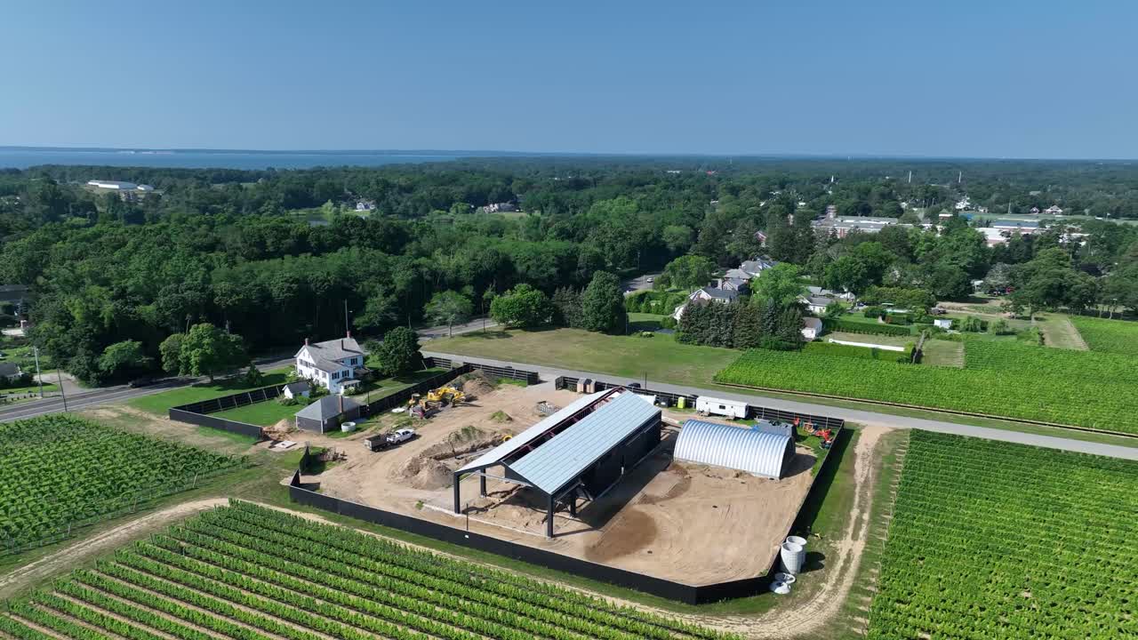 drone flying under blue sky over farmland and by the ocean