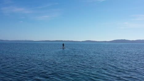 hombre de pie remando tiro aéreo tranquilo mar mediterráneo francia porquerolles