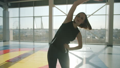 mujer estirándose en el gimnasio