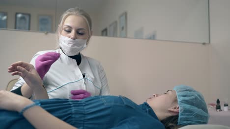 brow master helps girl to choose color for tattooing