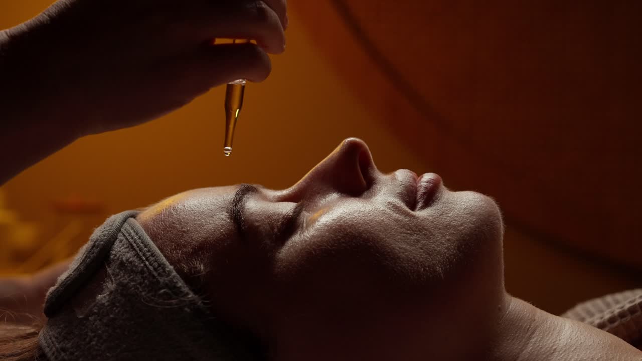 Nærbillede af kvinde der får ansigtsserumbehandling på spa