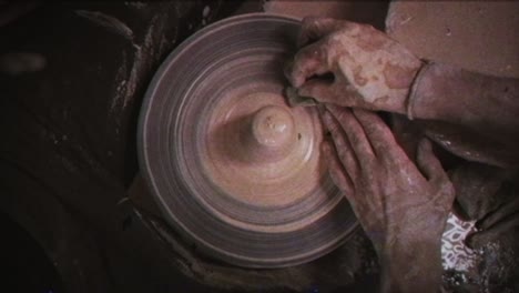 a potter teaches a woman to make clay dishes. a man takes a woman's hands. vintage effect.