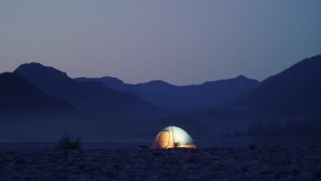 la luz en una carpa iluminada con fondo de montaña brilla y luego se apaga