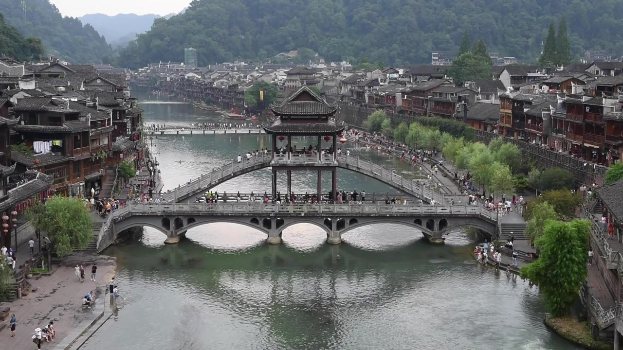 Com vista para a Cidade Antiga de Fenghuang, na Província de Hunan, China, esta vista deslumbrante destaca o encanto histórico da cidade com arquitetura chinesa tradicional, casas sobre palafitas e ruas de paralelepípedos.