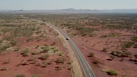 Vista-Aérea-Ascendente-De-Un-Automóvil-Solitario-Que-Conduce-A-Través-Del-Parque-Nacional-Karijini-De-Austalia-En-El-Calor-Del-Día