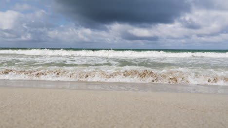 el hermoso mar azul verde rueda suavemente hacia la orilla y se estrella contra hermosas playas de arena