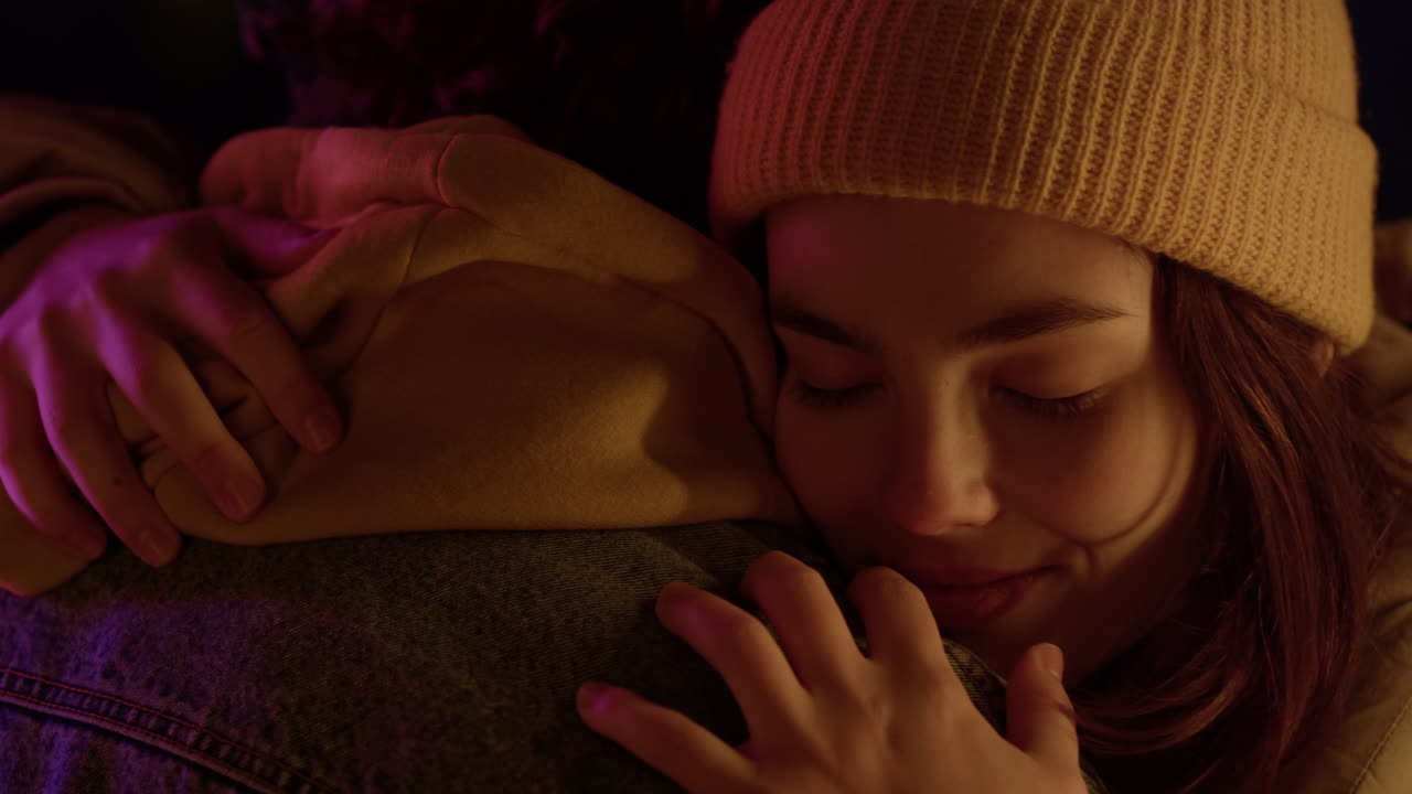 Smiling woman hugging unrecognizable man on romantic date on urban street.