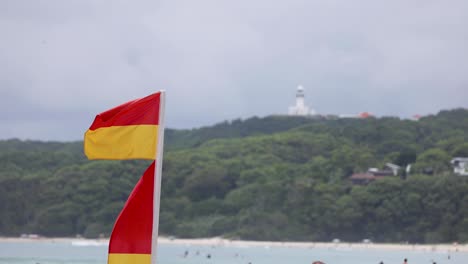 red and yellow flag waving against a coastal backdrop