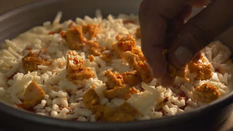 trozos de pollo colocados sobre pizza fresca