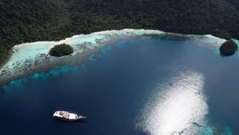close view on island with white sand beach and phinisi ship in raja ampat, wayag, indonesia