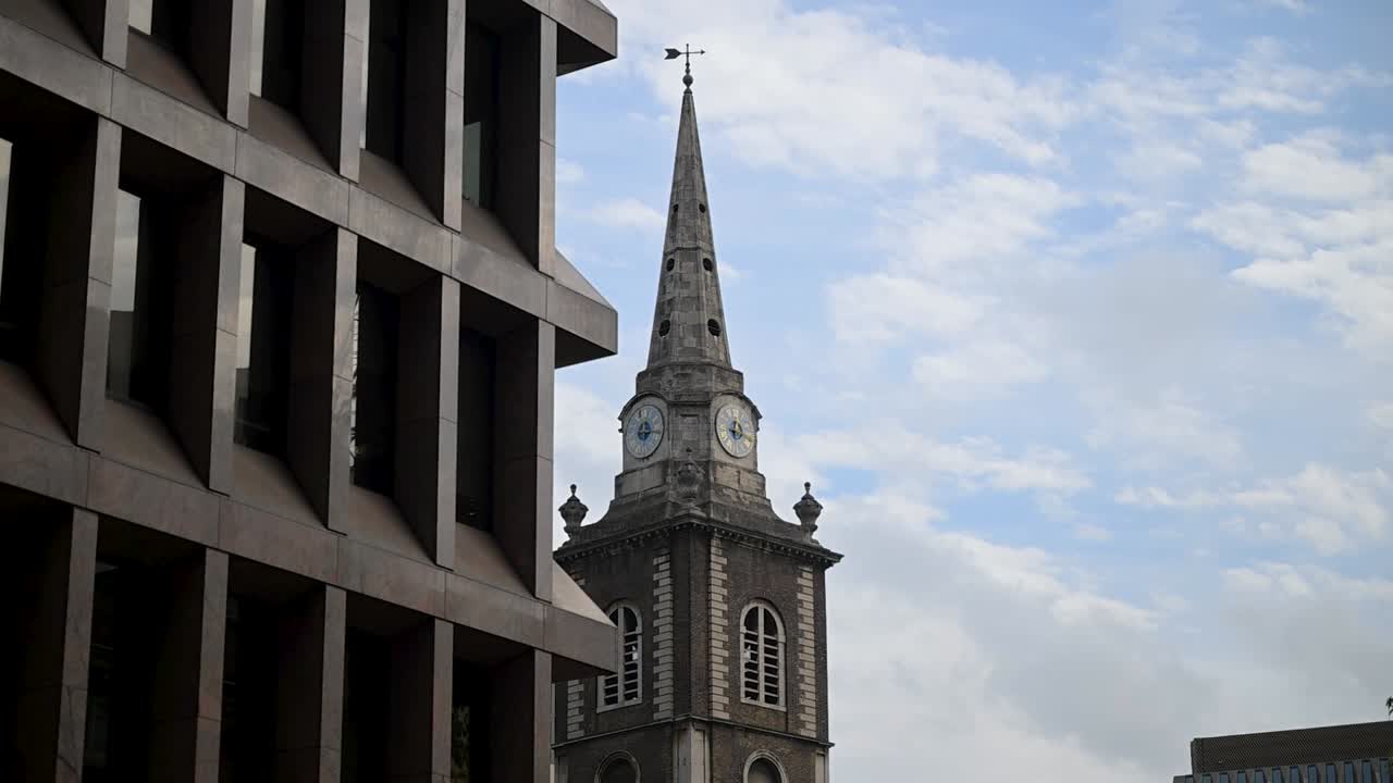 View looking towards the clock of St Botolph Without Aldgate in London, United Kingdom, highlighting historic architecture and cultural heritage