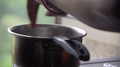 Mano-Poniendo-Jengibre-En-Té-Caliente-En-La-Estufa-Para-Hacer-Té