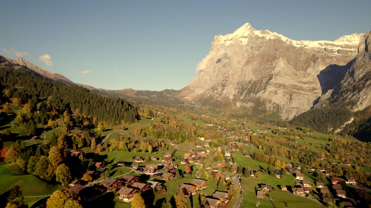 imágenes aéreas de drones dolly de izquierda a derecha sobre el colorido pueblo de grindelwald frente a wetterhorn en los alpes suizos