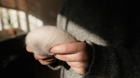 female hands touching soft, ball of yarn from mohair, close up