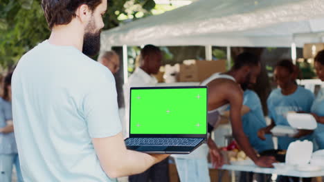 man holds device with green screen