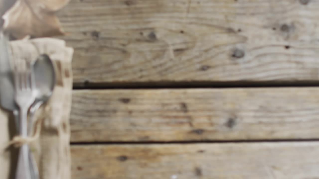 On opening orbs drifting upward across table over linen napkin cutlery leaves forming bokeh fading