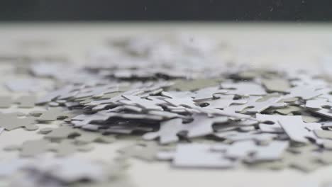 water drops falling on white and gray puzzle pieces laying randomly on a white surface