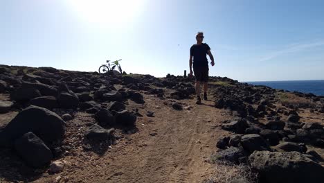 hiking at the coast of lanzarote sun in the back sea rocks waves