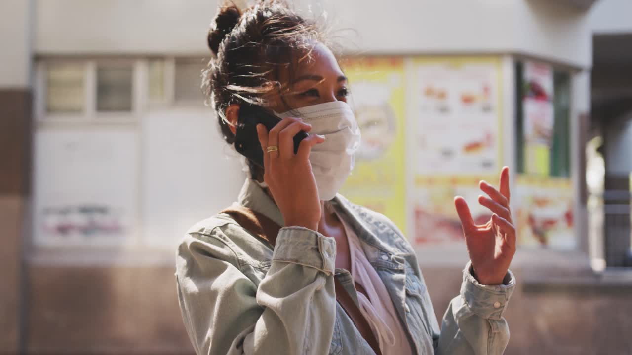 Mixed race woman wearing medical coronavirus mask on the street