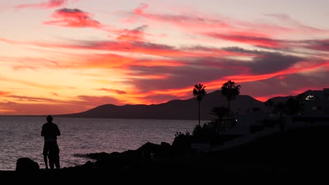 sunset over the ocean with people watching