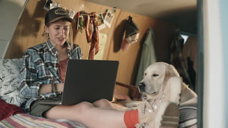 female tourist talking on video call on laptop in camper van