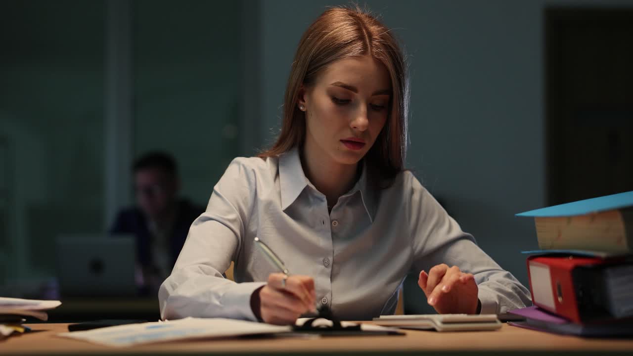 Женщина работает поздно в офисе
