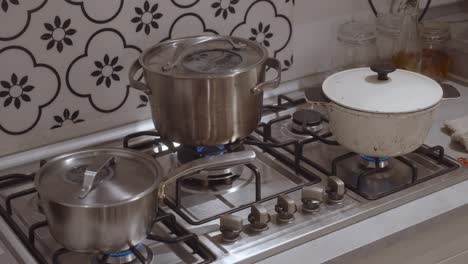 three cooking pots standing on gas oven cooker