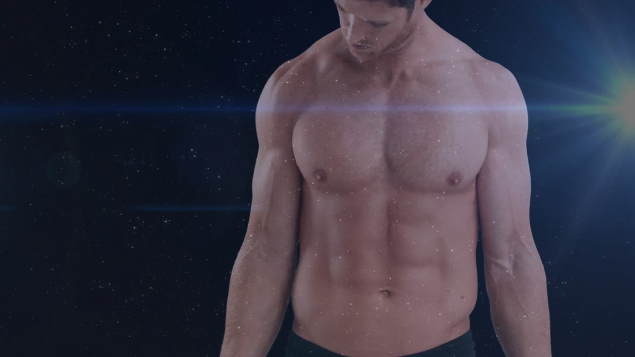 Man holding chrome dumbbells starting arm curls, checking fitness form, particles around lens flare