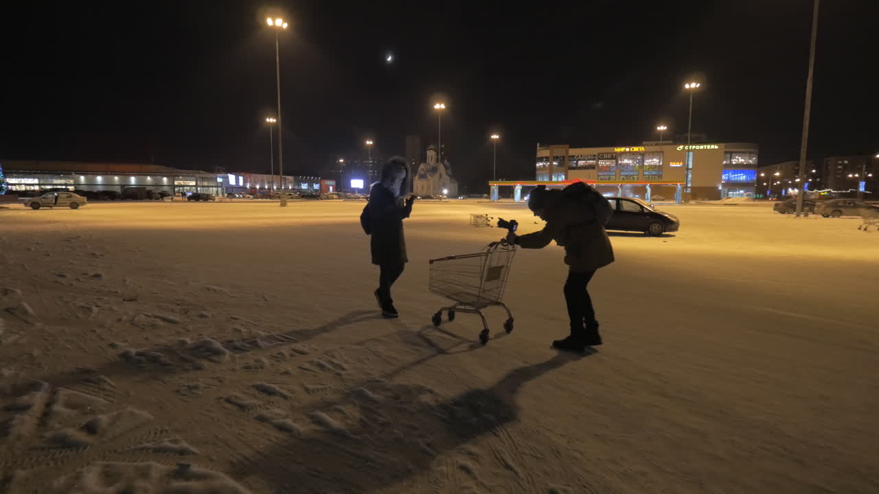 상점 근처에서 걸어다니는 여자와 드폰을 사용하는 여성의 비디오를 만드는 것