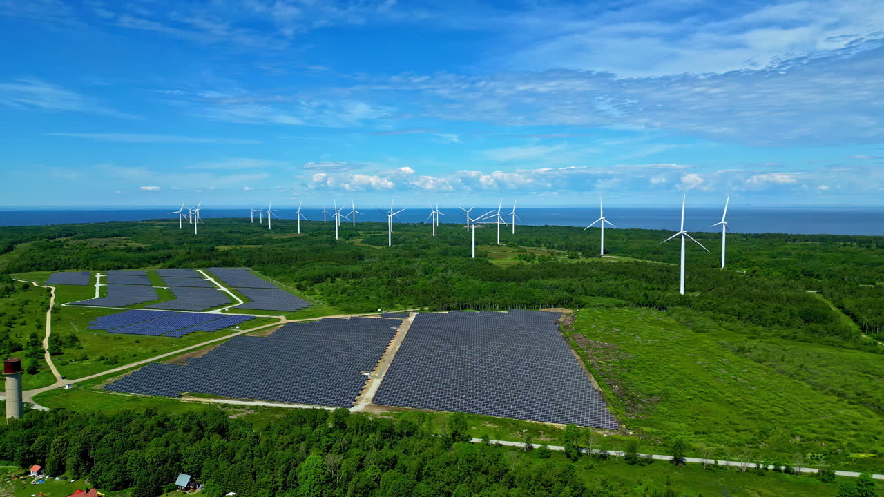 풍력 터빈을 배경으로 태양광 현장을 돌고 있는 파노라마 드론