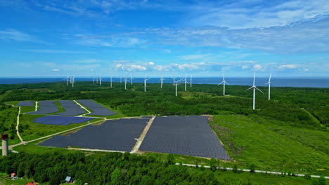 Panoramic-drone-shot-circling-a-solar-field-with-wind-turbine-in-the-background