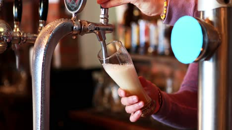 barman filling beer from beer pump