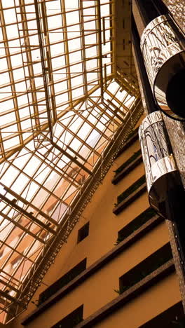 modern hotel atrium with glass roof and elevators