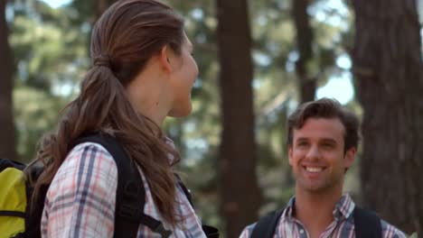 pareja sonriente en una caminata en el campo