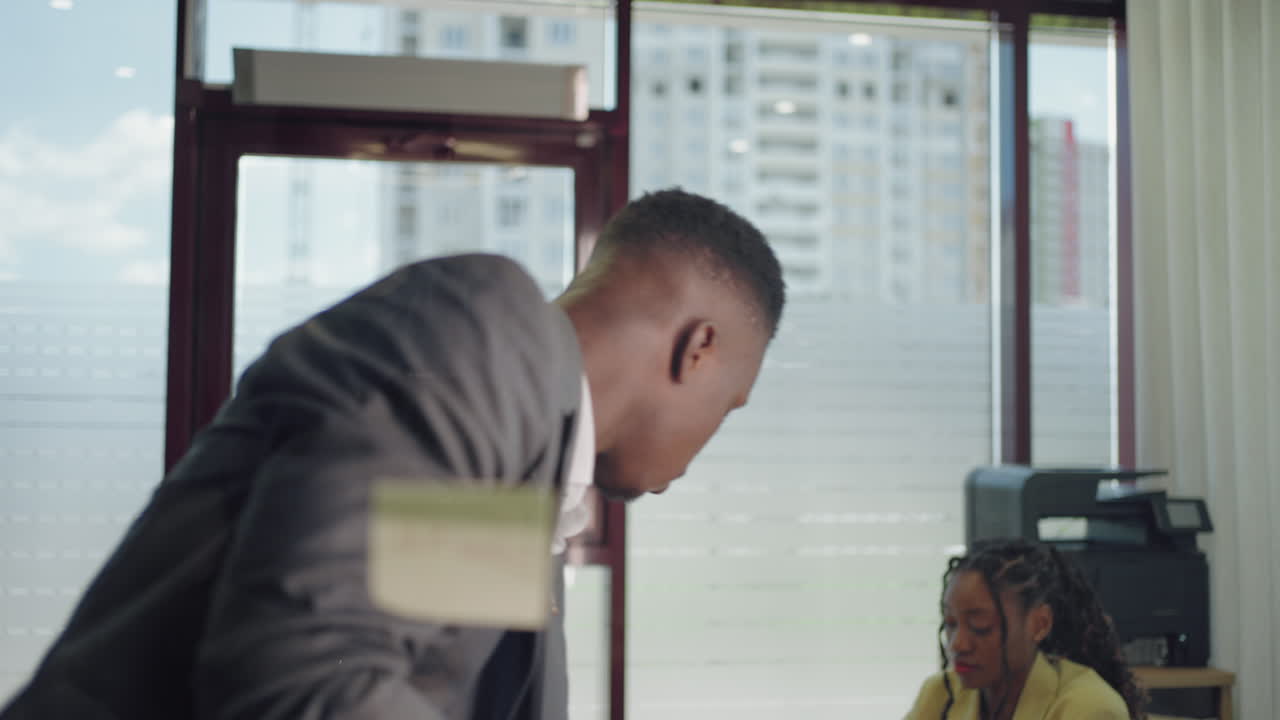 아프리카계 미국인 사업가: 스티키 노트를 사용해 브레인스토밍, 유리 화이트보드 위에서 문제 해결 전략, 리더: 사무실에서 프로젝트 기한에 대한 솔루션을 보여주는 사람.